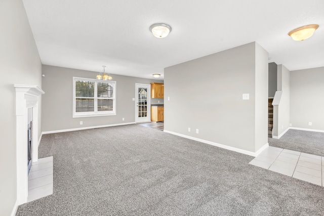 1373 Mackenzie Ct, Clarksville, TN 37042 - unfurnished living room with carpet floors, a chandelier, stairs, tile patterned flooring, and a fireplace