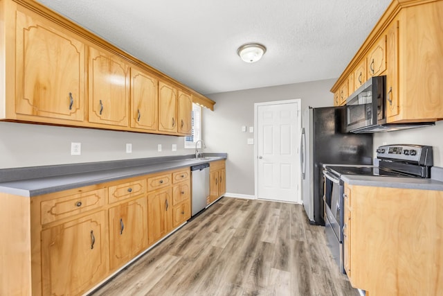 1373 Mackenzie Ct, Clarksville, TN 37042 - kitchen featuring stainless steel appliances, light wood-style flooring, dark countertops, and a textured ceiling