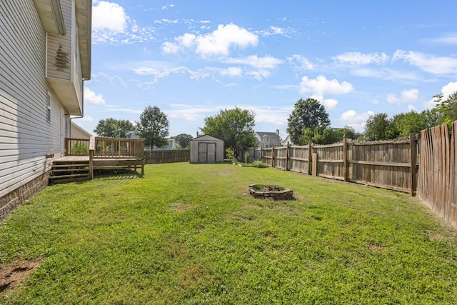 1373 Mackenzie Ct, Clarksville, TN 37042 - fenced backyard featuring a wooden deck, a storage unit, and an outdoor fire pit