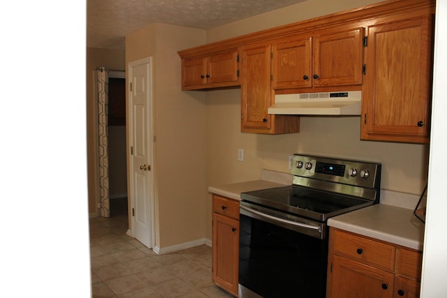 109 Hunter Dr, Mount Juliet, TN 37122 - kitchen with under cabinet range hood, electric range, brown cabinets, light countertops, and light tile patterned floors
