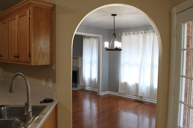 109 Hunter Dr, Mount Juliet, TN 37122 - kitchen featuring dark wood finished floors, brown cabinetry, a chandelier, light countertops, and decorative light fixtures