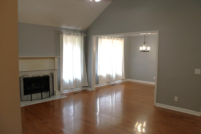 109 Hunter Dr, Mount Juliet, TN 37122 - unfurnished living room with a chandelier, a fireplace with flush hearth, wood finished floors, high vaulted ceiling, and a ceiling fan