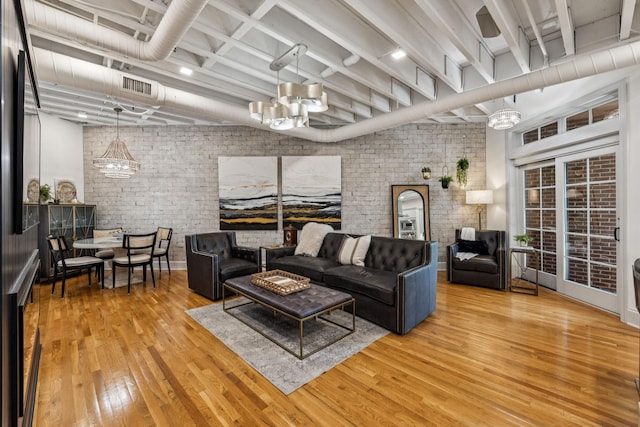 320 Liberty Pike Unit 205, Franklin, TN 37064 - living room featuring wood finished floors, brick wall, and a chandelier