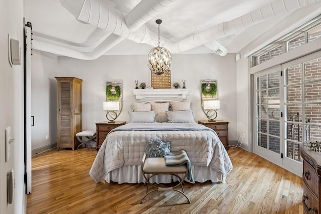 320 Liberty Pike Unit 205, Franklin, TN 37064 - bedroom featuring a chandelier, wood finished floors, and access to exterior