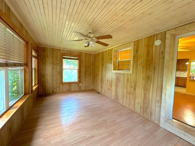 104 Tobaccoport Dock Rd, Bumpus Mills, TN 37028 - empty room featuring light wood-type flooring, ceiling fan, wooden ceiling, and wood walls