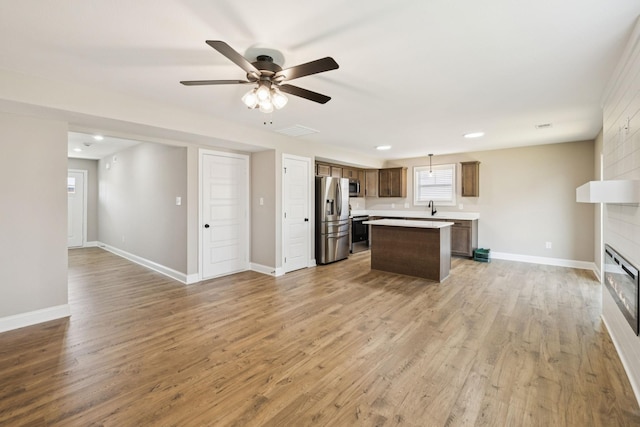 145 Irish Hls, Clarksville, TN 37042 - kitchen with stainless steel appliances, open floor plan, a kitchen island, ceiling fan, and light wood-style floors