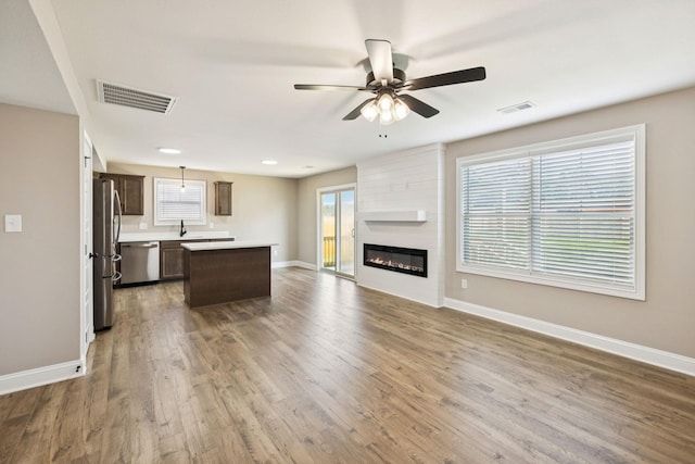 145 Irish Hls, Clarksville, TN 37042 - unfurnished living room with wood finished floors, a ceiling fan, and a large fireplace