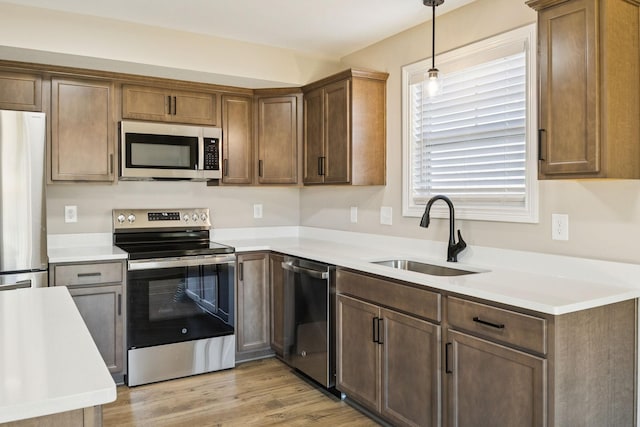 145 Irish Hls, Clarksville, TN 37042 - kitchen featuring stainless steel appliances, hanging light fixtures, light wood-style flooring, and light countertops