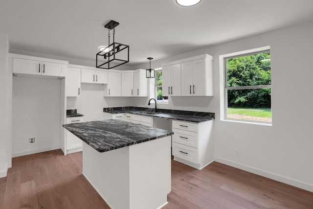 306 Forrest St, Watertown, TN 37184 - kitchen with light wood-type flooring, white cabinetry, dark stone countertops, hanging light fixtures, and a kitchen island