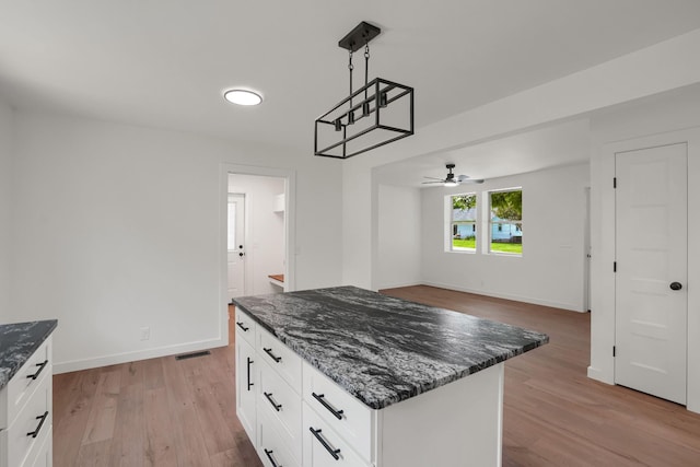 306 Forrest St, Watertown, TN 37184 - kitchen with light wood-style flooring, ceiling fan, dark stone countertops, white cabinets, and decorative light fixtures