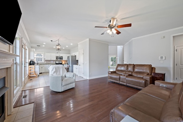 312 Retriever Ct, Clarksville, TN 37043 - living room with crown molding, a ceiling fan, a fireplace, light wood finished floors, and plenty of natural light