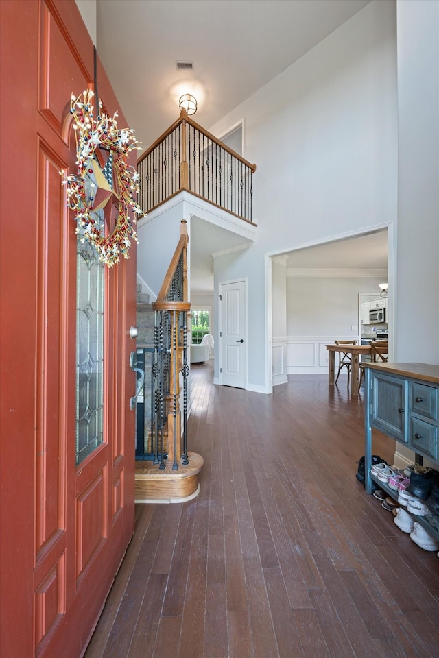 312 Retriever Ct, Clarksville, TN 37043 - foyer entrance featuring a high ceiling, stairs, dark wood-style floors, a decorative wall, and wainscoting