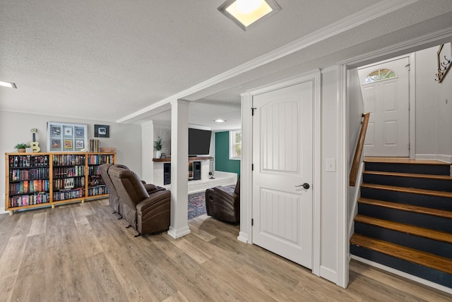 236 Slayden Cir, Clarksville, TN 37040 - living room featuring light wood-style flooring, a textured ceiling, stairway, and a brick fireplace