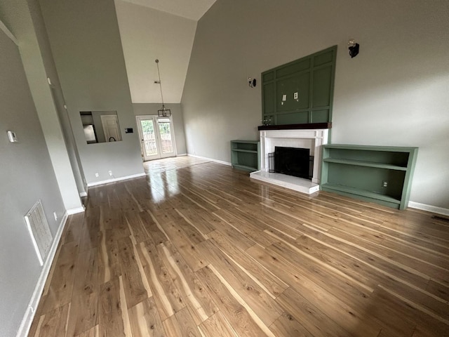 3421 Foxrun Ln, Clarksville, TN 37042 - unfurnished living room with high vaulted ceiling, hardwood / wood-style flooring, and a fireplace with raised hearth