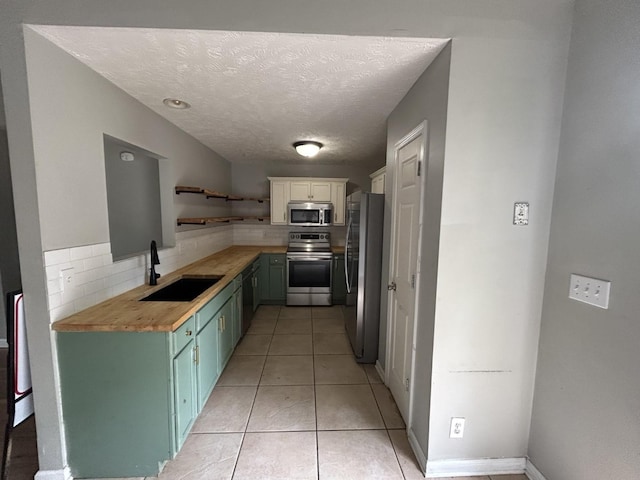 3421 Foxrun Ln, Clarksville, TN 37042 - kitchen with appliances with stainless steel finishes, wooden counters, open shelves, backsplash, and a textured ceiling