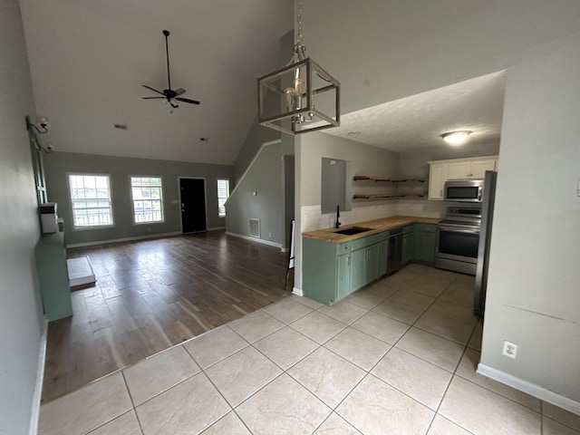 3421 Foxrun Ln, Clarksville, TN 37042 - kitchen featuring stainless steel appliances, ceiling fan, open shelves, light countertops, and high vaulted ceiling
