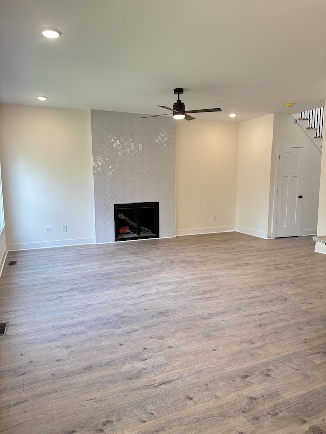 317 Wesson Dr, Clarksville, TN 37043 - unfurnished living room with a fireplace, a ceiling fan, wood finished floors, recessed lighting, and stairway