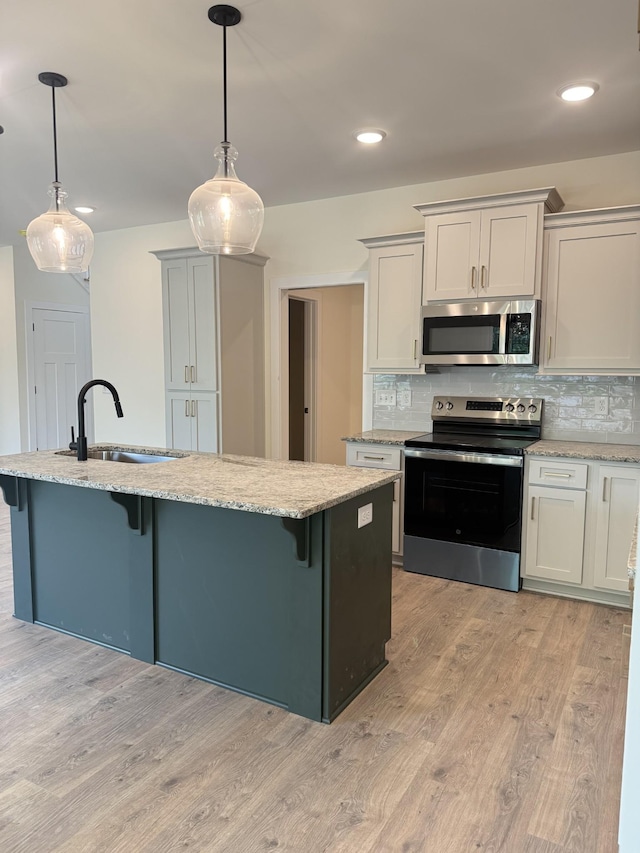 317 Wesson Dr, Clarksville, TN 37043 - kitchen with stainless steel appliances, a kitchen breakfast bar, light wood-style flooring, and recessed lighting