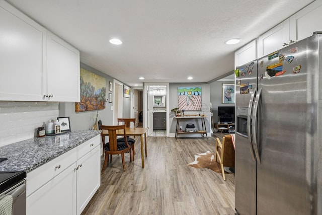 813 Lonnie St, Columbia, TN 38401 - kitchen with appliances with stainless steel finishes, light wood-style flooring, white cabinetry, stone counters, and a textured ceiling