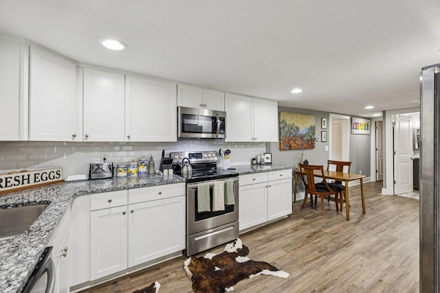 813 Lonnie St, Columbia, TN 38401 - kitchen featuring stainless steel appliances, white cabinets, tasteful backsplash, light wood finished floors, and recessed lighting