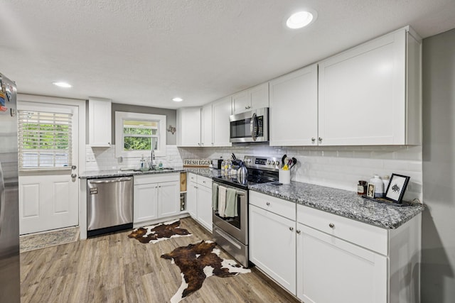 813 Lonnie St, Columbia, TN 38401 - kitchen with stainless steel appliances, wood finished floors, tasteful backsplash, white cabinetry, and recessed lighting
