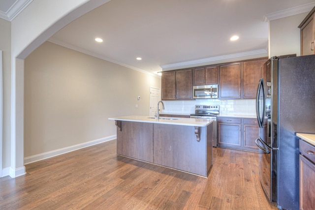 213 Vintage Way, Lebanon, TN 37087 - kitchen with appliances with stainless steel finishes, wood finished floors, light countertops, decorative backsplash, and ornamental molding