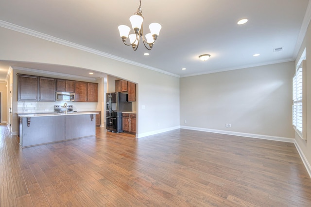 213 Vintage Way, Lebanon, TN 37087 - unfurnished living room with arched walkways, a chandelier, wood finished floors, crown molding, and recessed lighting