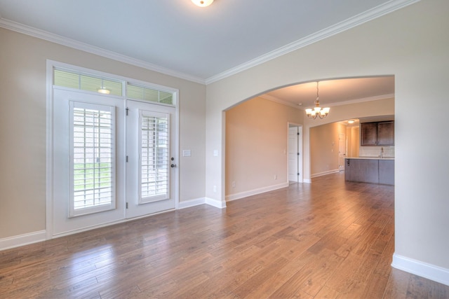 213 Vintage Way, Lebanon, TN 37087 - unfurnished living room with a chandelier, arched walkways, crown molding, and wood finished floors