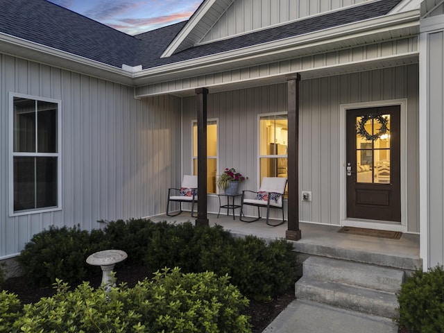 204 Locust St, Mc Ewen, TN 37101 - exterior entry at dusk with covered porch, a shingled roof, and board and batten siding