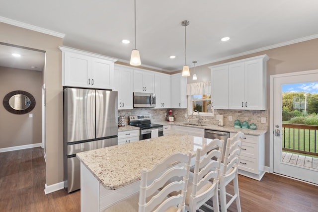 204 Locust St, Mc Ewen, TN 37101 - kitchen featuring appliances with stainless steel finishes, backsplash, white cabinets, a kitchen island, and crown molding