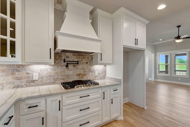 3058 Henley Way, Spring Hill, TN 37174 - kitchen with custom exhaust hood, stainless steel gas cooktop, a ceiling fan, white cabinetry, and light wood-style floors