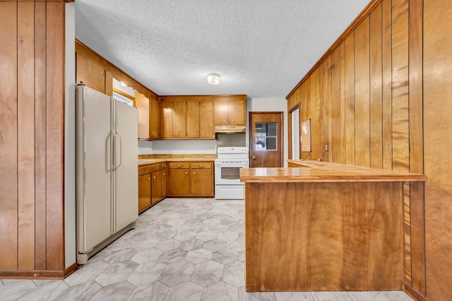 207 Short St, Clarksville, TN 37042 - kitchen with white appliances, brown cabinetry, under cabinet range hood, a peninsula, and a textured ceiling