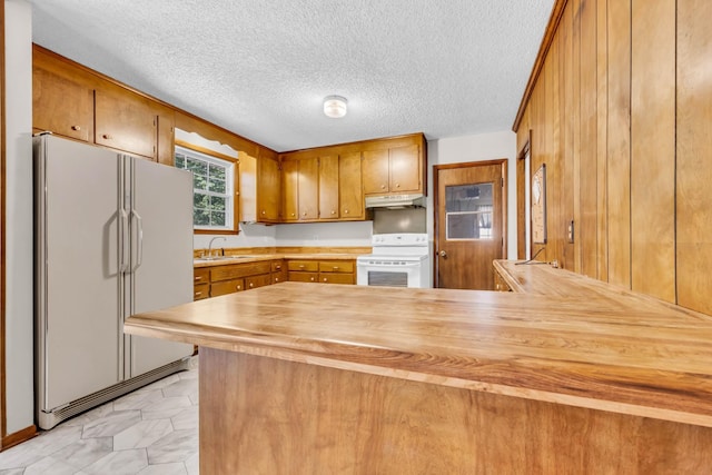 207 Short St, Clarksville, TN 37042 - kitchen featuring white appliances, brown cabinetry, a peninsula, wood counters, and light marble finish flooring