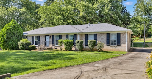 207 Short St, Clarksville, TN 37042 - single story home with driveway, brick siding, a front yard, roof with shingles, and view of wooded area