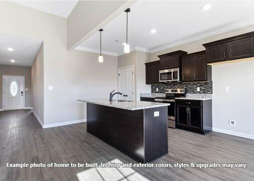 918 Vendue Ave, Clarksville, TN 37042 - kitchen with appliances with stainless steel finishes, wood finished floors, backsplash, a kitchen island with sink, and decorative light fixtures