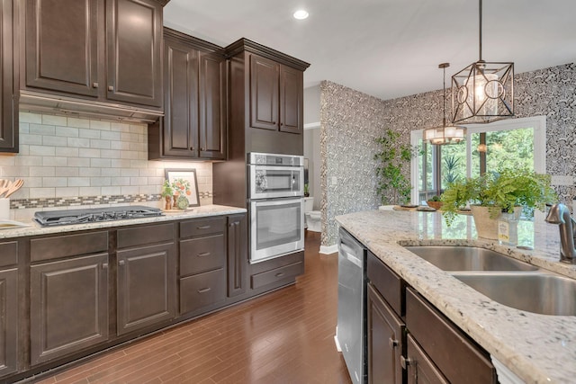 412 Warren Hill Dr, Mount Juliet, TN 37122 - kitchen featuring stainless steel appliances, dark brown cabinets, dark wood finished floors, decorative backsplash, and a chandelier