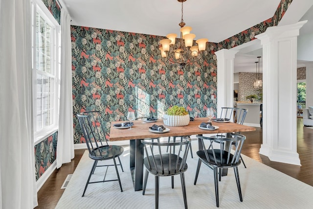 412 Warren Hill Dr, Mount Juliet, TN 37122 - dining room featuring ornate columns, wallpapered walls, a chandelier, an accent wall, and wood finished floors