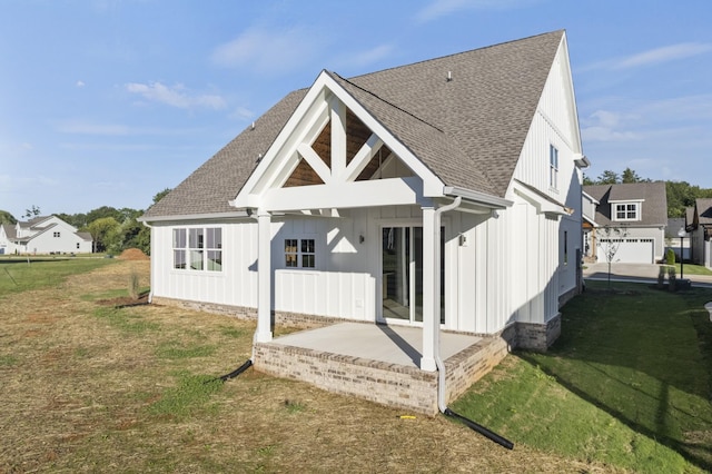 316 Campfire Ct, Winchester, TN 37398 - back of property with board and batten siding, a patio area, roof with shingles, and a lawn