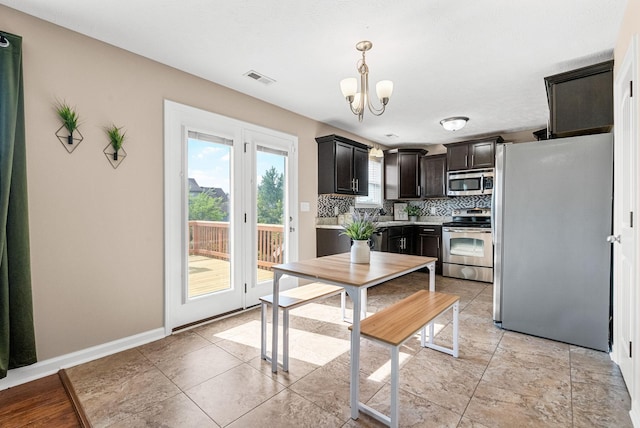 3754 Gray Fox Dr, Clarksville, TN 37040 - kitchen with appliances with stainless steel finishes, a chandelier, pendant lighting, light countertops, and backsplash