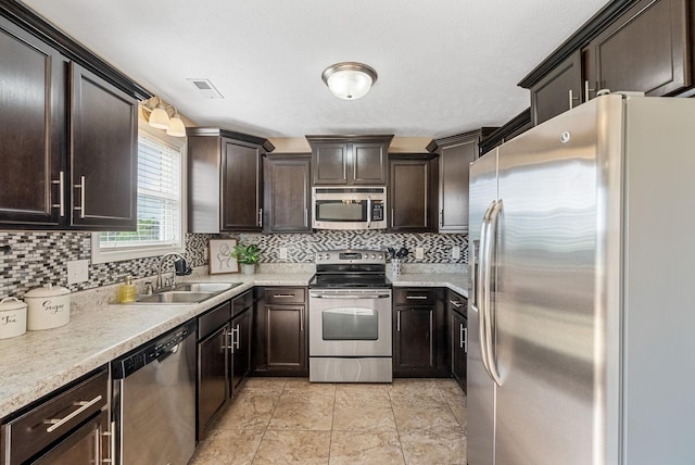 3754 Gray Fox Dr, Clarksville, TN 37040 - kitchen featuring stainless steel appliances, dark brown cabinets, tasteful backsplash, and light countertops