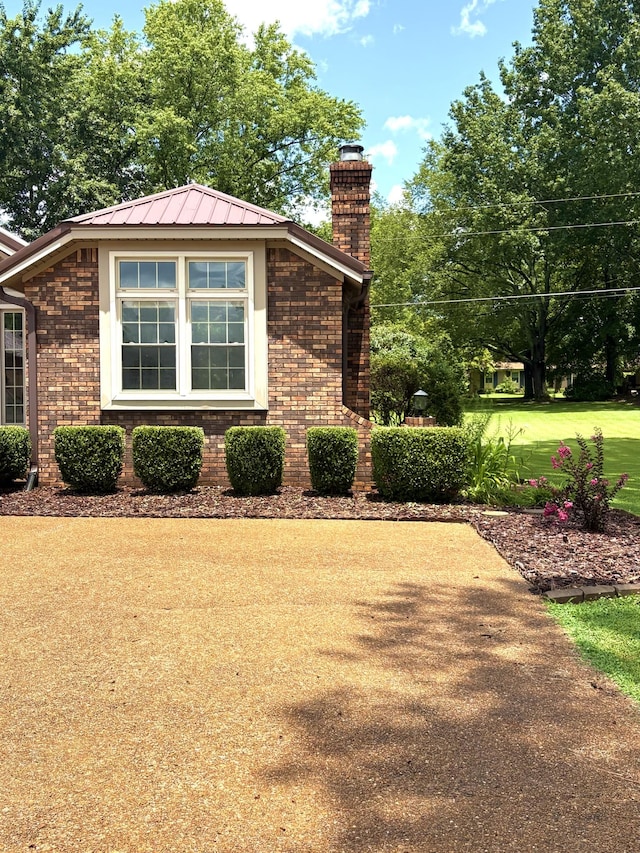 806 Sharon Cir, Lawrenceburg, TN 38464 - view of side of home with a chimney, brick siding, and a metal roof