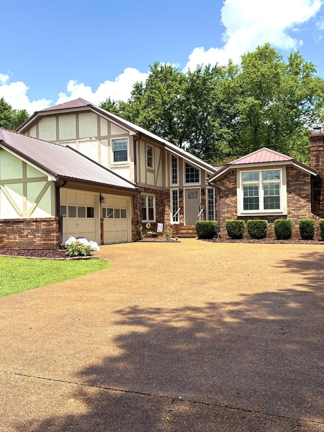 806 Sharon Cir, Lawrenceburg, TN 38464 - view of front facade featuring a garage, a chimney, concrete driveway, a metal roof, and stucco siding