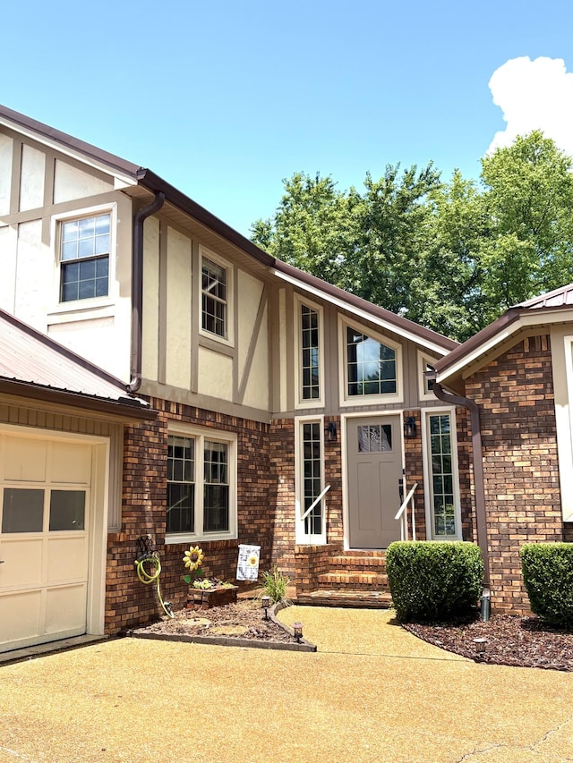 806 Sharon Cir, Lawrenceburg, TN 38464 - view of front of property featuring stucco siding, a garage, brick siding, and a metal roof