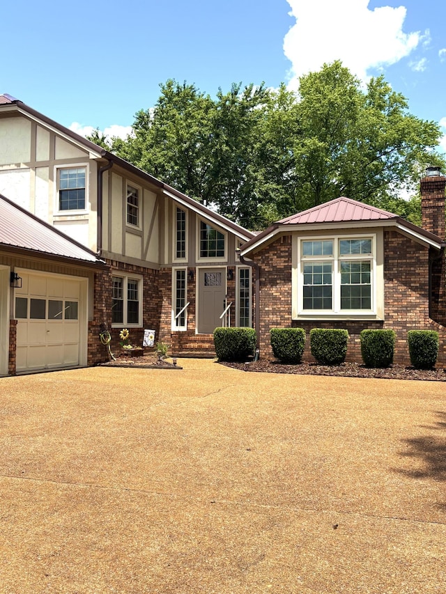 806 Sharon Cir, Lawrenceburg, TN 38464 - view of front facade featuring a chimney, driveway, a metal roof, and brick siding