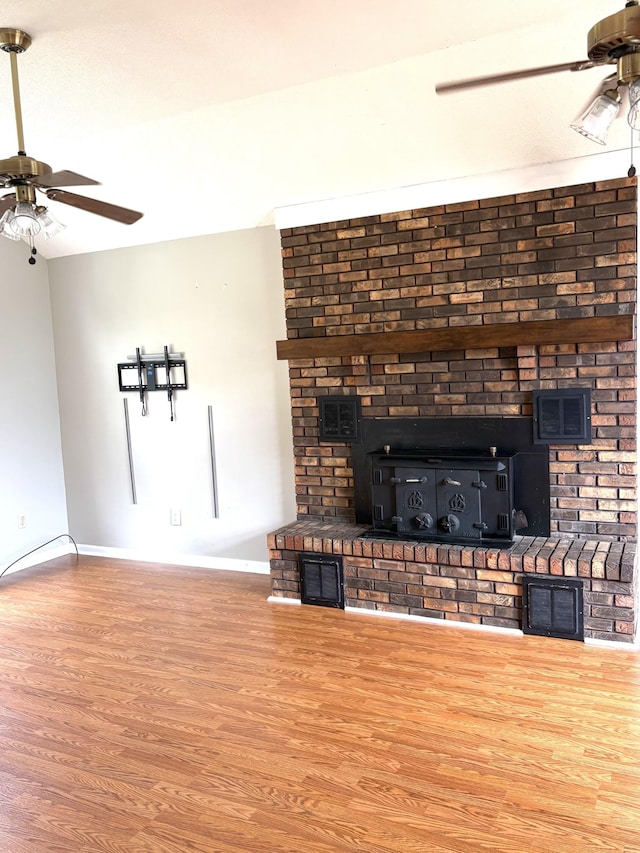 806 Sharon Cir, Lawrenceburg, TN 38464 - unfurnished living room featuring a ceiling fan, wood finished floors, and a wood stove