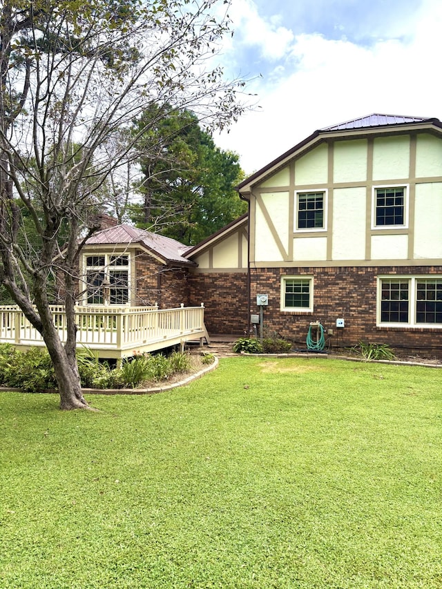 806 Sharon Cir, Lawrenceburg, TN 38464 - back of house with stucco siding, a wooden deck, a lawn, and brick siding