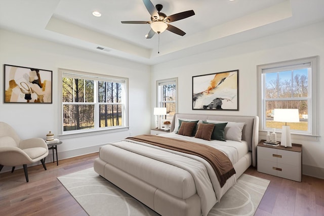 3200 Crockett Pointe, Jasper, TN 37347 - bedroom featuring a raised ceiling, multiple windows, light wood-style floors, recessed lighting, and a ceiling fan