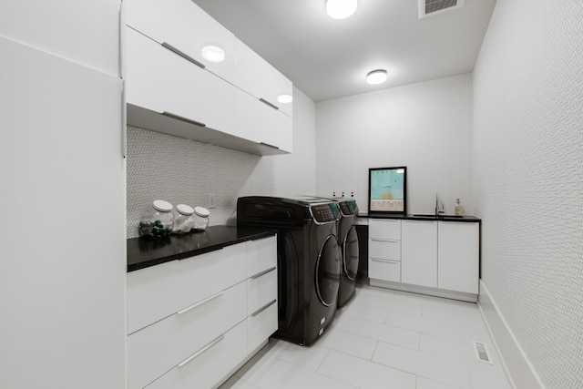 4606 Shys Hill Rd, Nashville, TN 37215 - washroom featuring washer and clothes dryer, cabinet space, and light tile patterned flooring