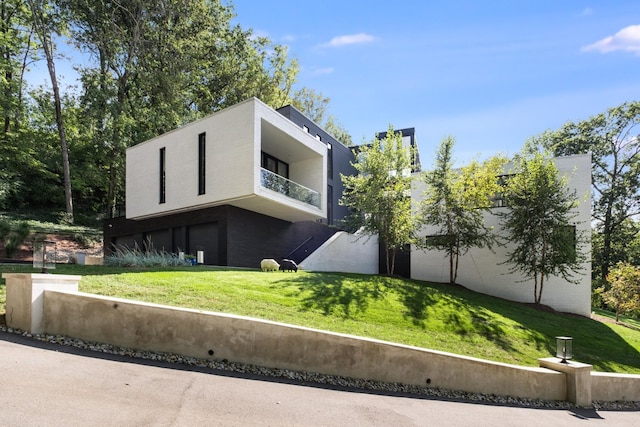 4606 Shys Hill Rd, Nashville, TN 37215 - view of front of house with an attached garage, a balcony, a front lawn, and stucco siding