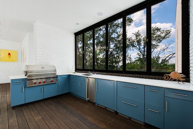 4606 Shys Hill Rd, Nashville, TN 37215 - kitchen with blue cabinetry, healthy amount of natural light, light countertops, dark wood-style floors, and brick wall